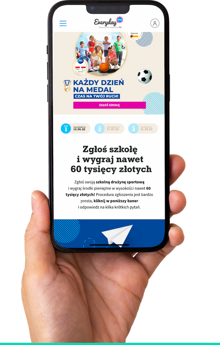 A hand holding a smartphone displaying the polish EverydayMe website with promotional content related with the Biedronka Olympics.